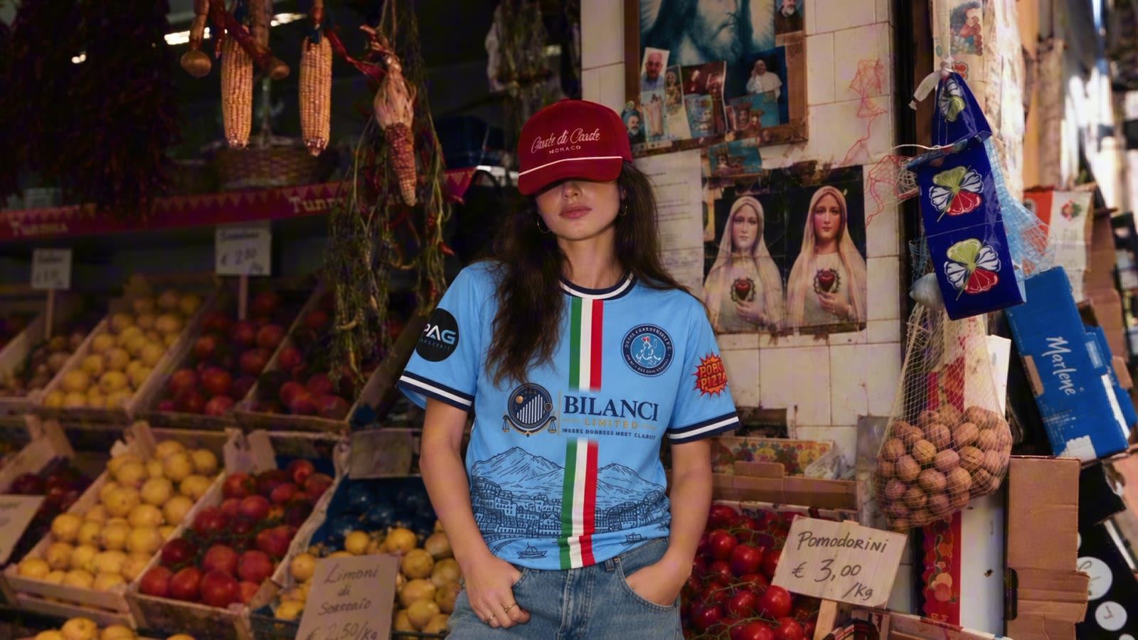A fan wearing the Royal Parthenope 2026/27 shirt at a market in Naples